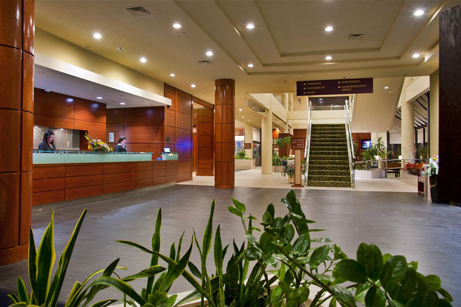 lobby area with reception desk to the left, and a stairwell to the right 