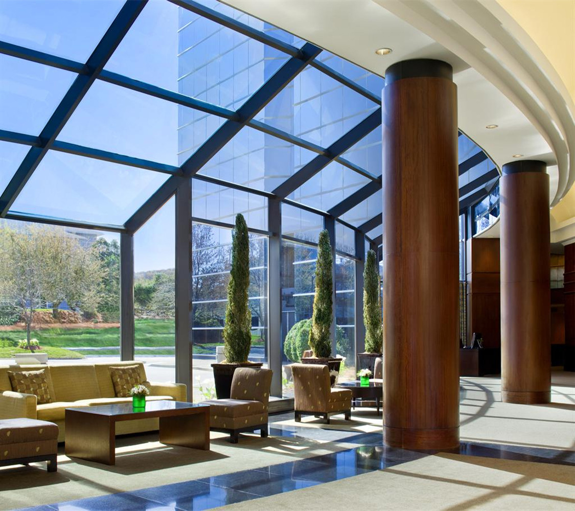 reception area with light shining through windows, and pillars connecting the ceiling to the wall 