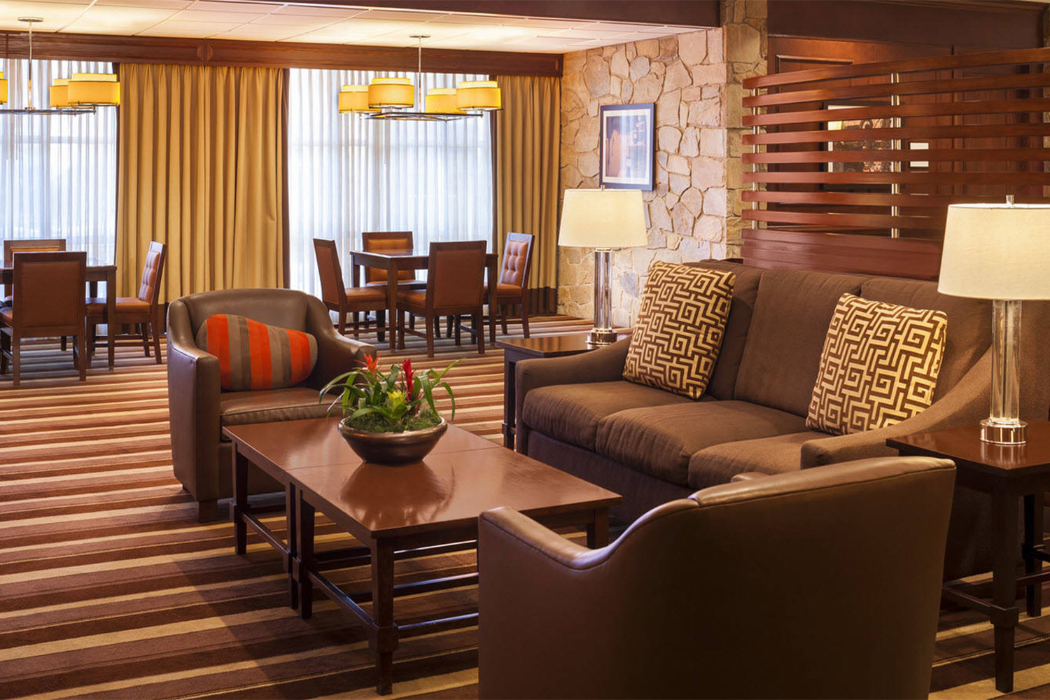 lobby area of hotel, with brown leather couches and cushions 