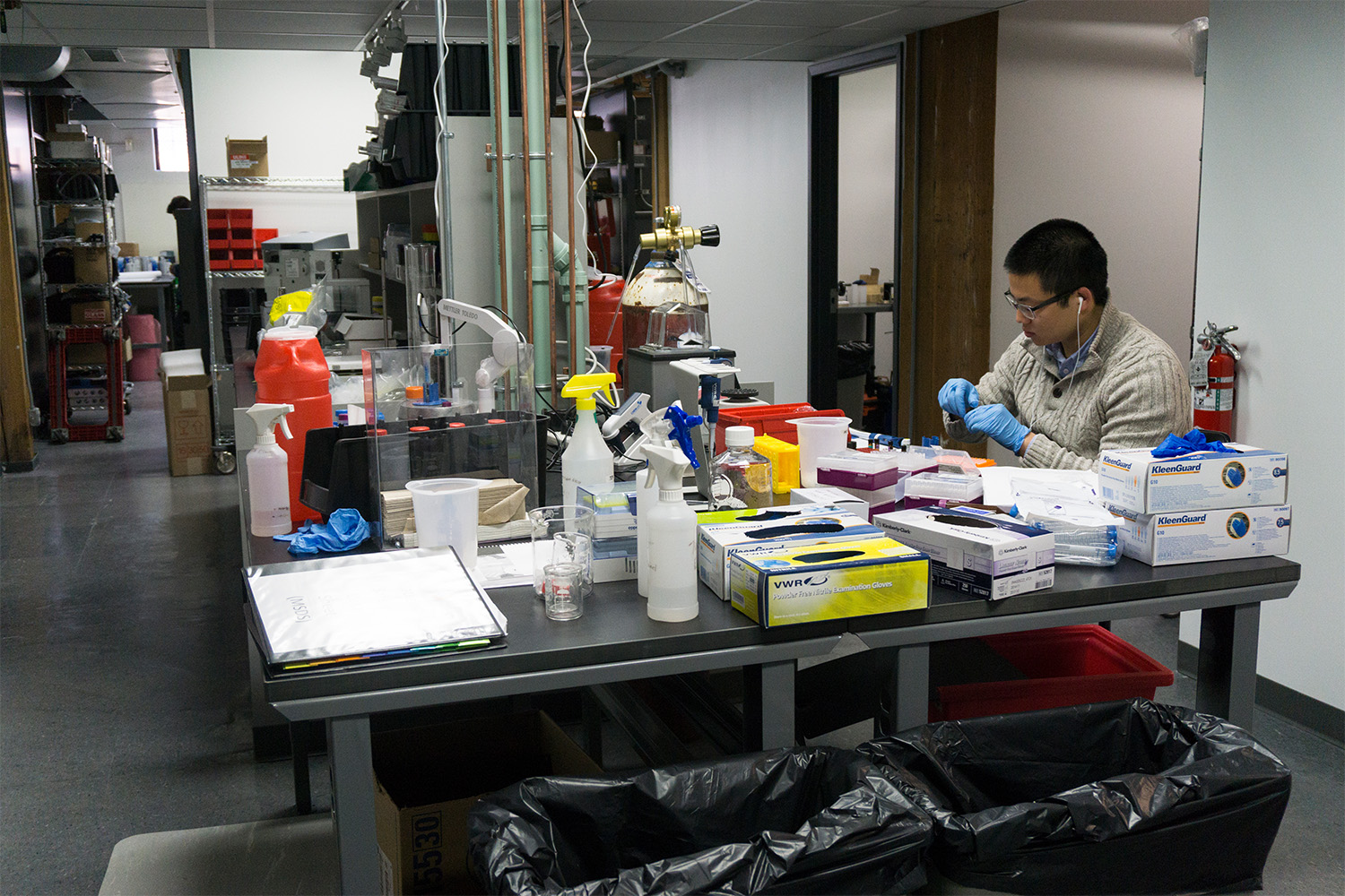 Asian man working at station in bioscience facility 