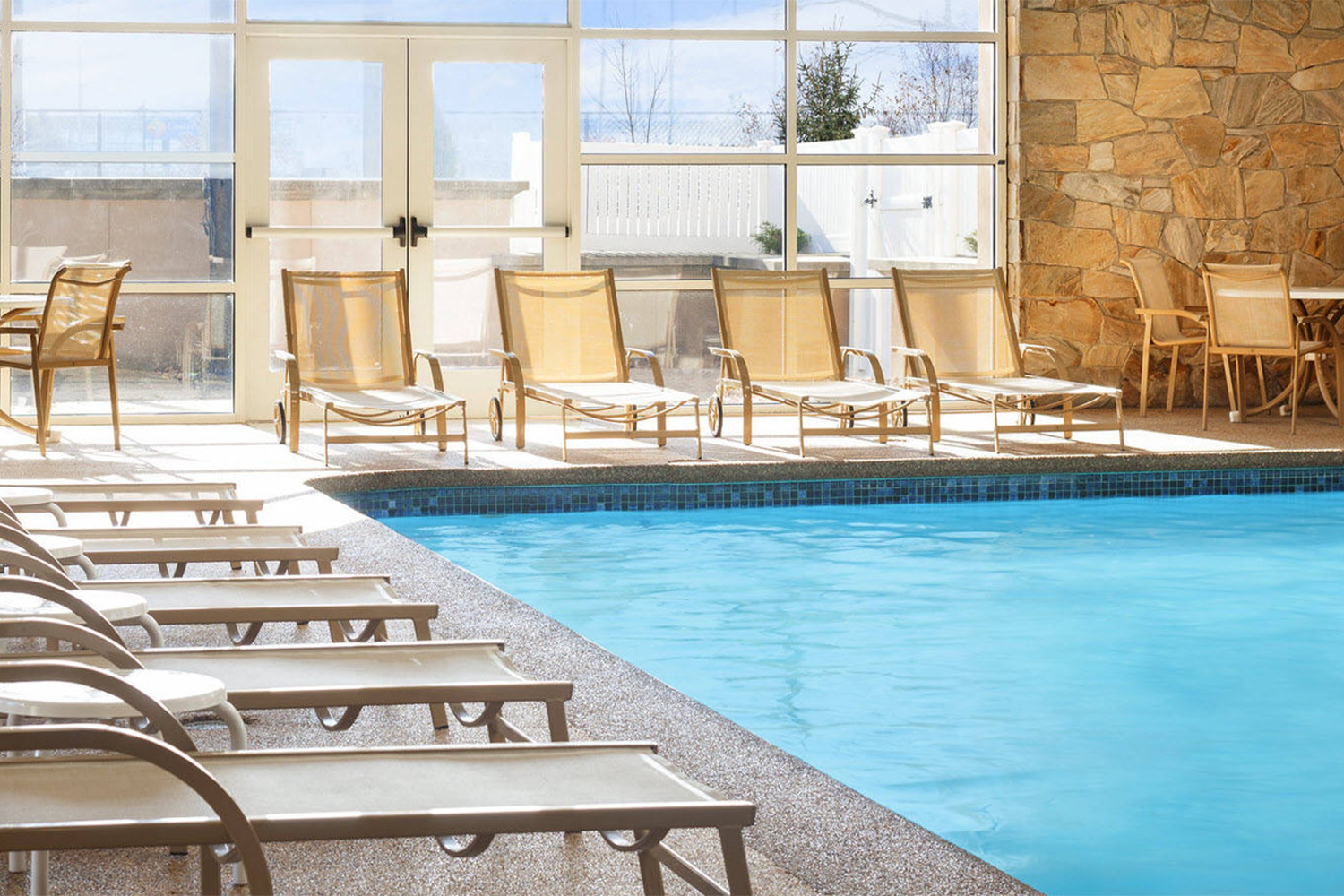 indoor pool in hotel, with white lounge chairs 