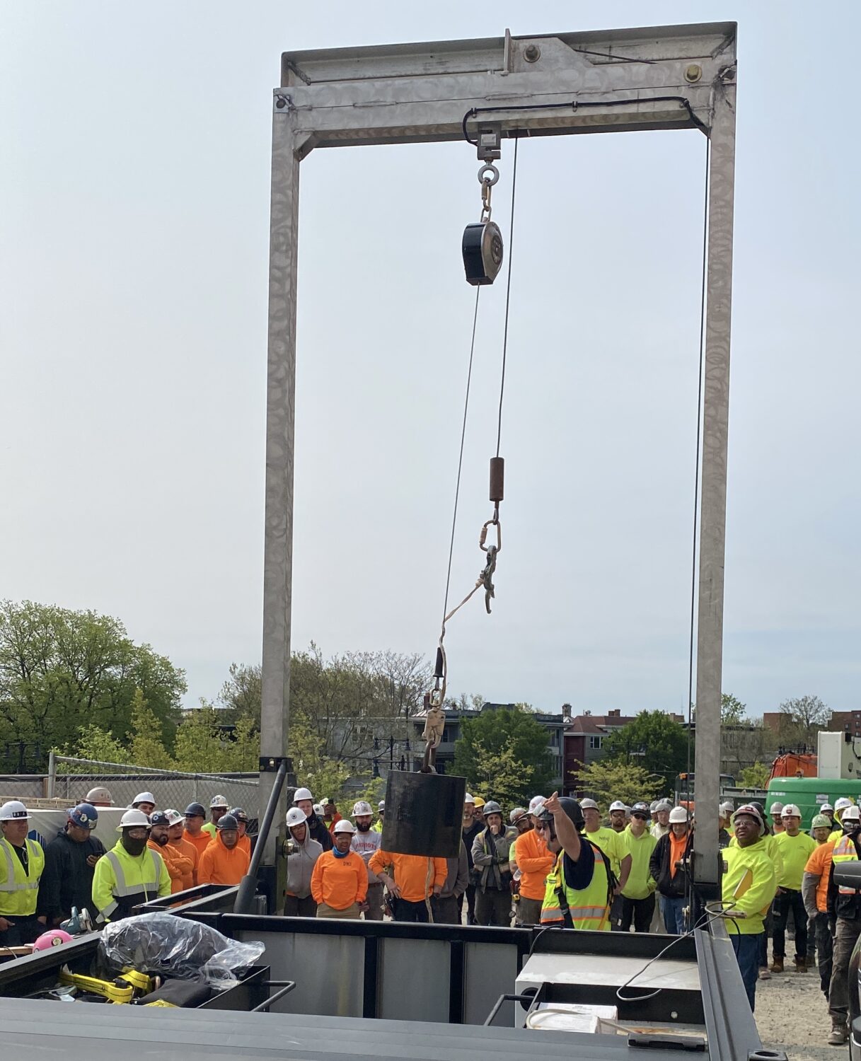 construction men standing around pulley system 