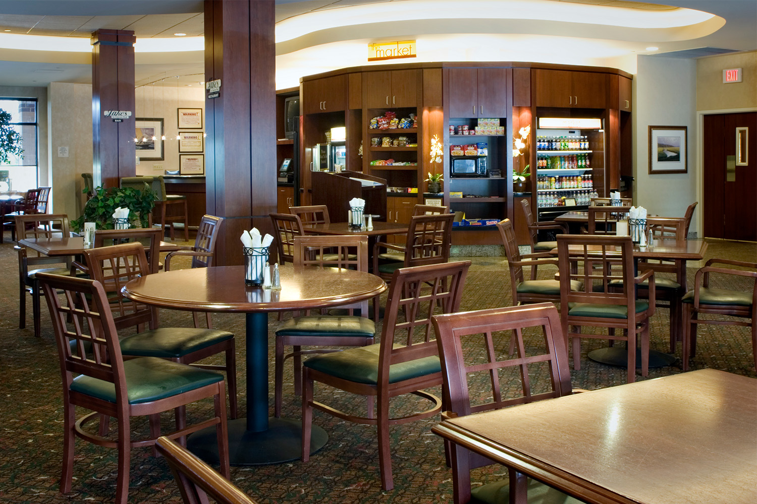 dining area with mahogany chairs, and view of bar area behind tables