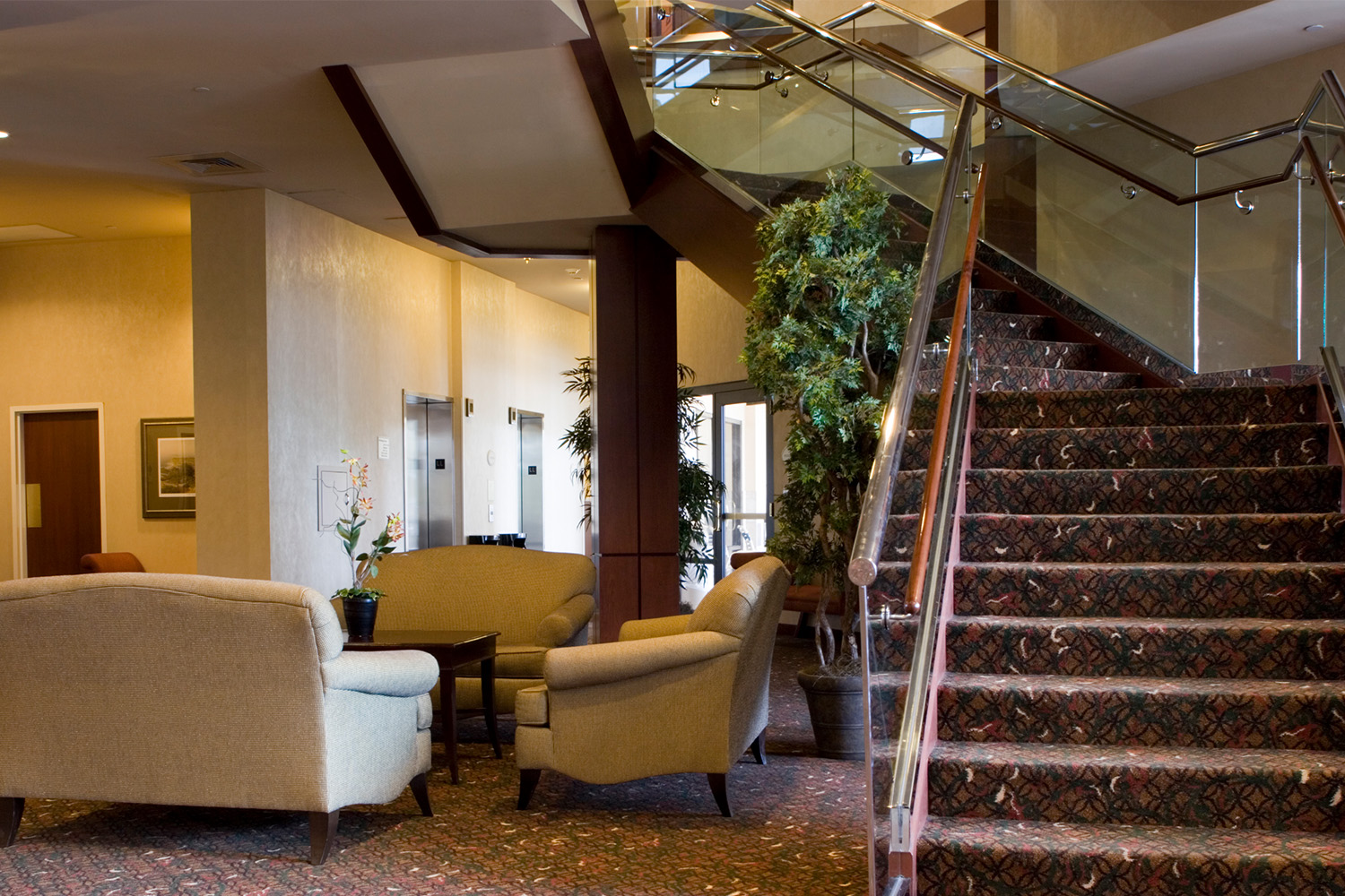 lobby area with view of stairwell, and three couches in the distance 