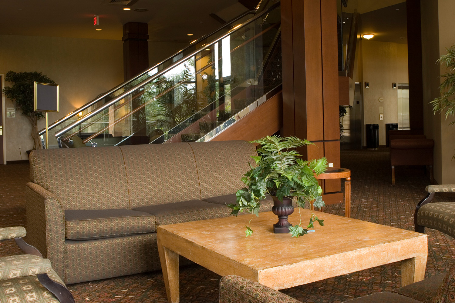 view of couch and wooden table in hotel lobby area 