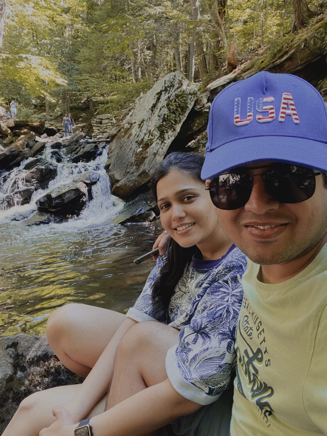 Rinkesh and his wife sitting by a stream 