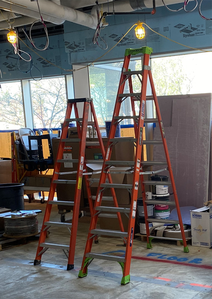 two red ladders next to each other in a building under construction 