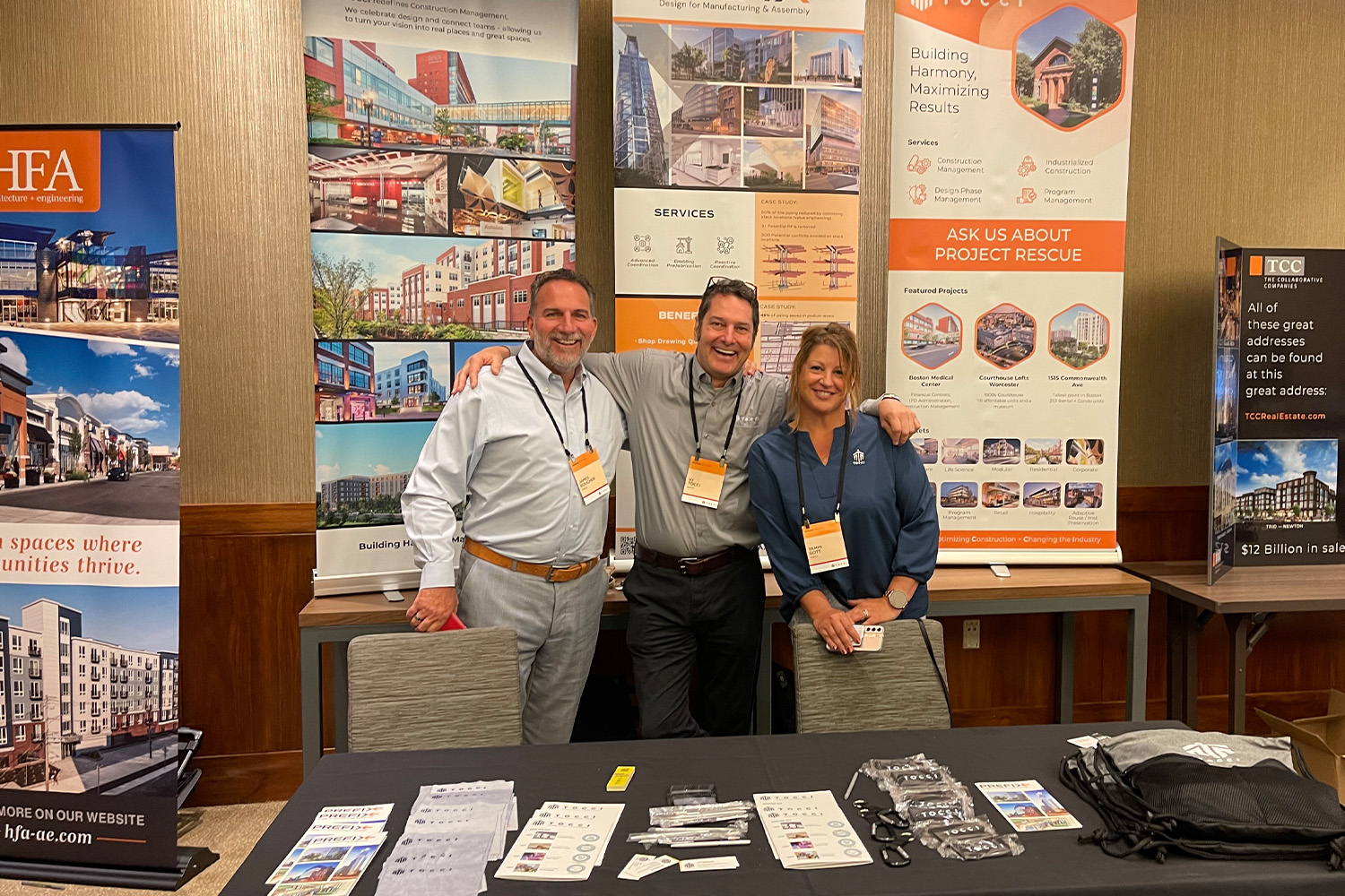 James, VJ and Tammi posing behind booth at BISNOW event 