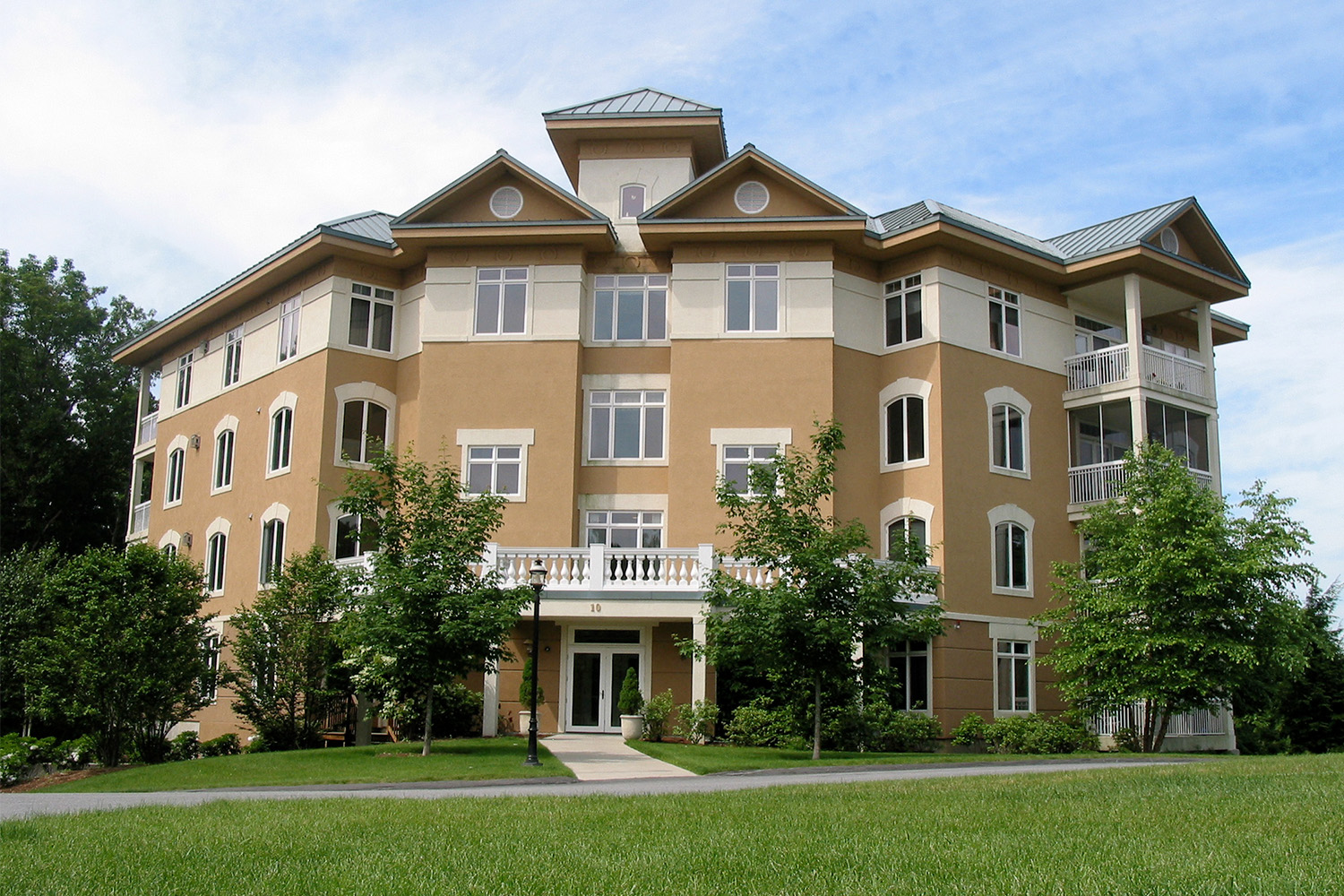 view of tan senior living facility with 3 sides seen with frontal view 