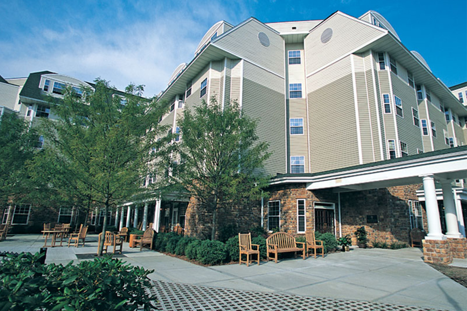 angled view of the entrance to Rivervue senior facilities, with trees in the front 