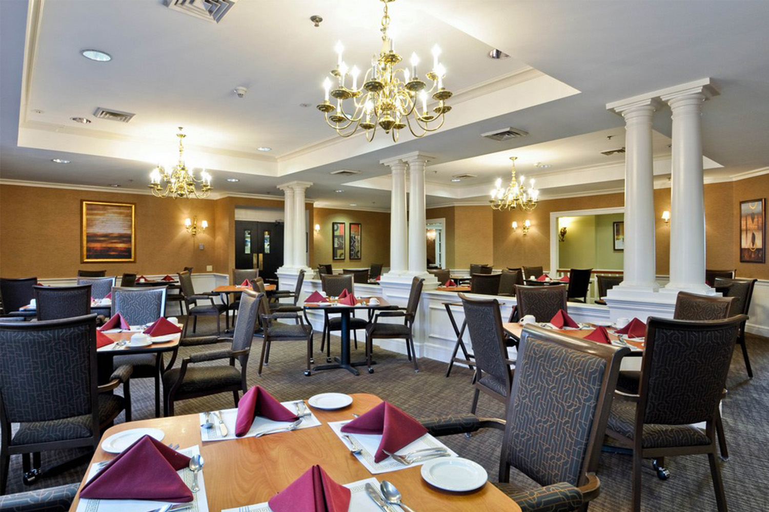 elegant dining area with folded maroon napkins on tables 