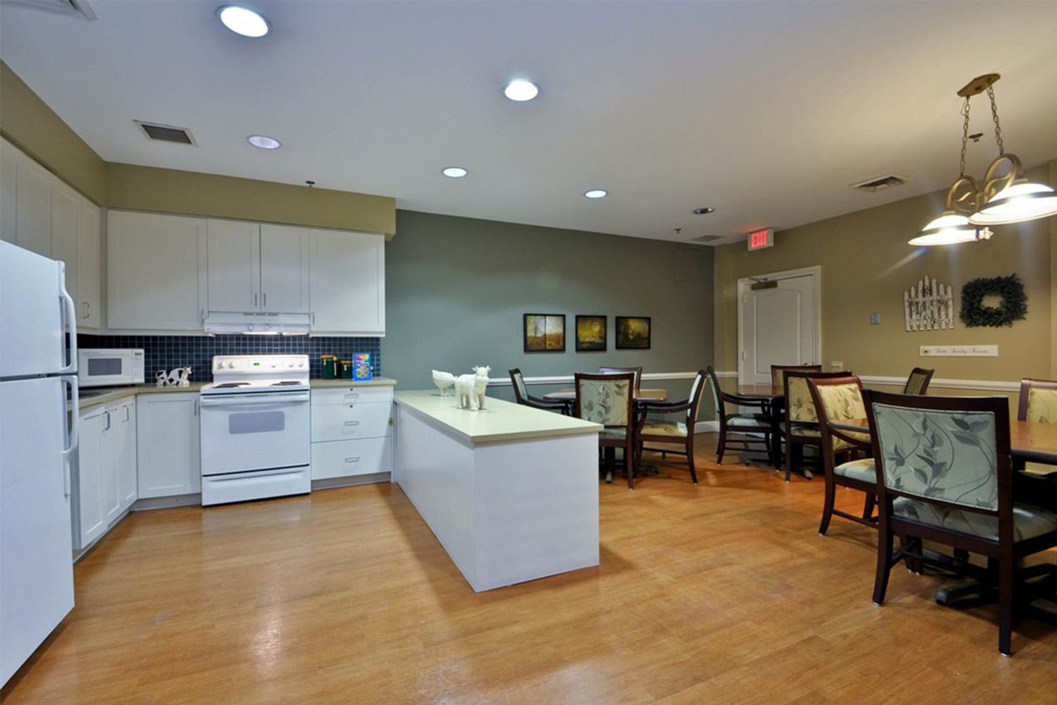 kitchen with white cabinets and refrigerator next to dark brown wooden table and chairs 