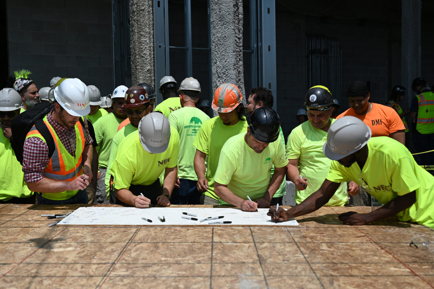 Construction workers signing topping off banner at 1515 Topping Off ceremony 