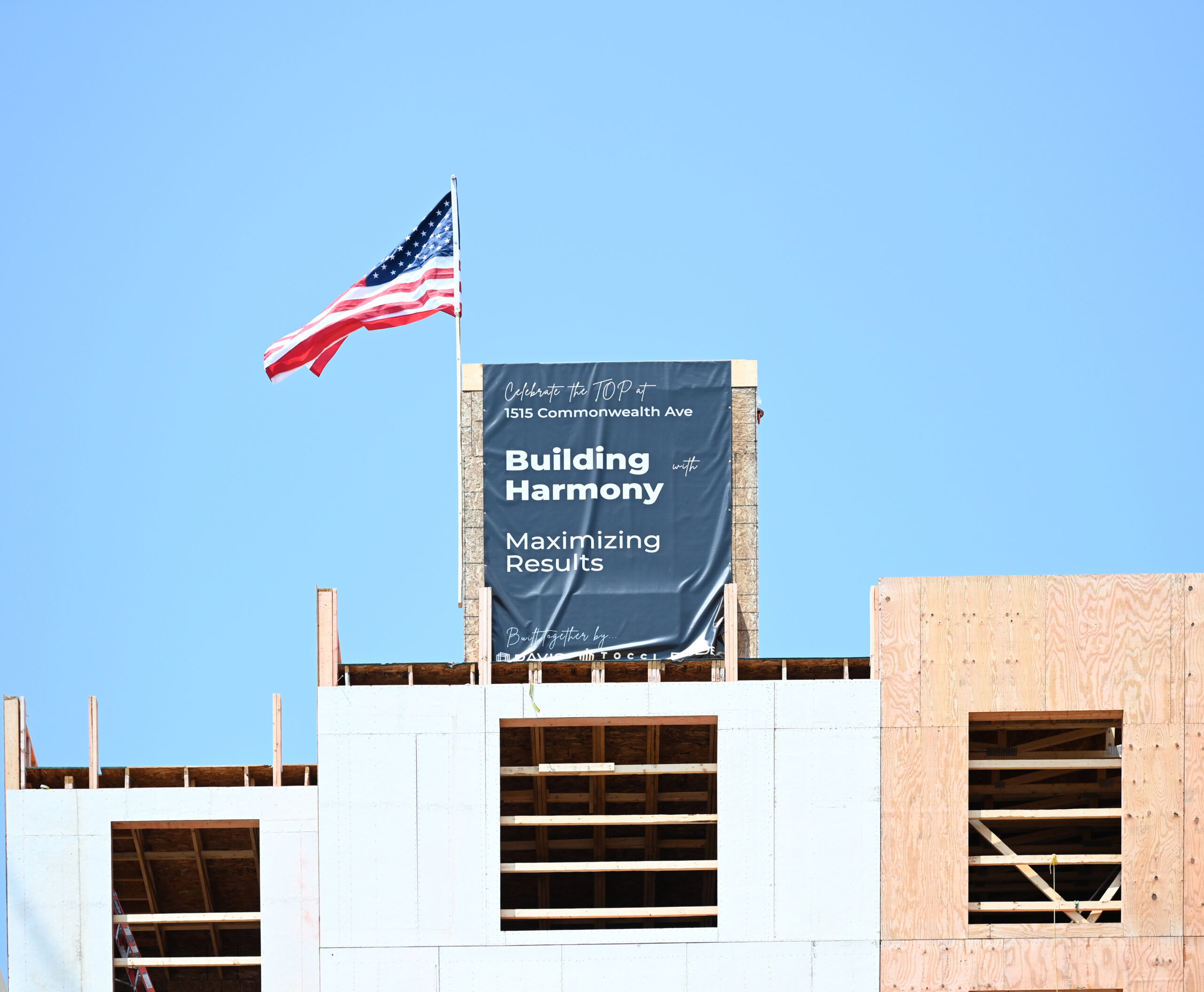 1515 banner lowered onto building during topping off ceremony
