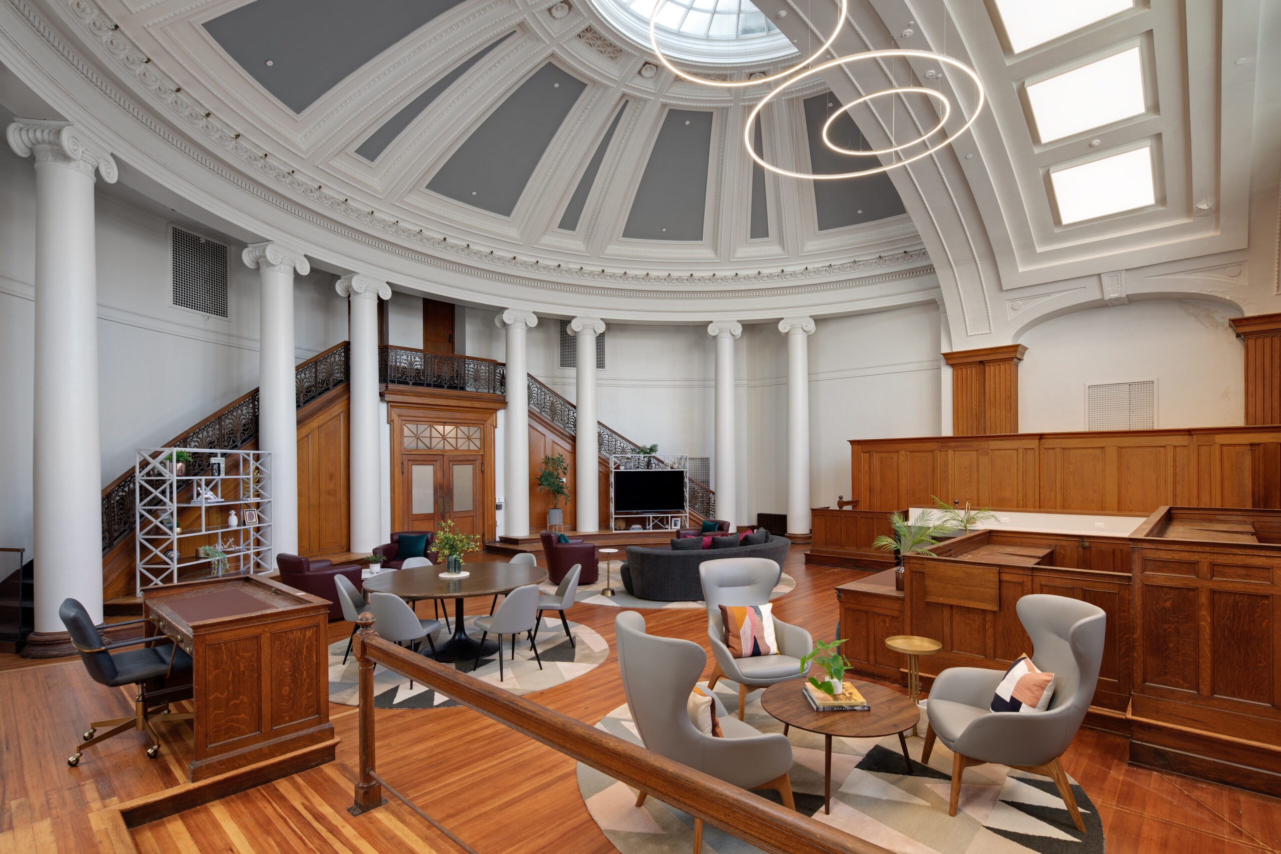 a former courtroom converted into a domed lounge with original columns and modern seating, at Courthouse Lofts.